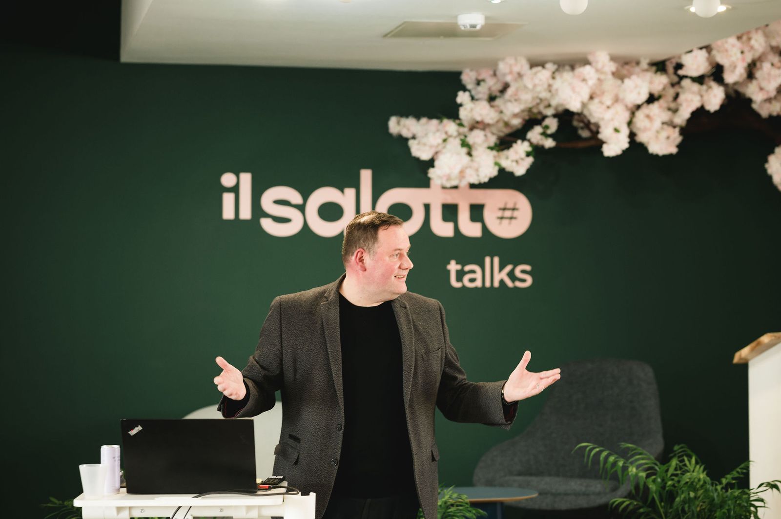 A speaker in front of the Il Salotto talks wall